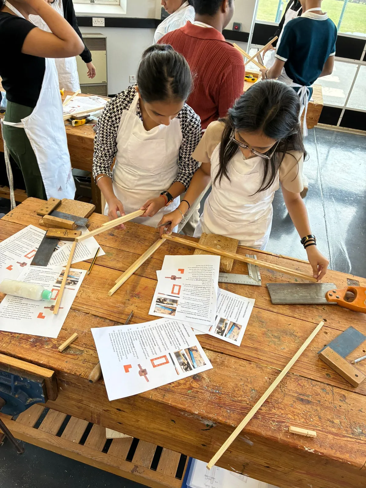 Students learning practical skills in a design and technology workshop